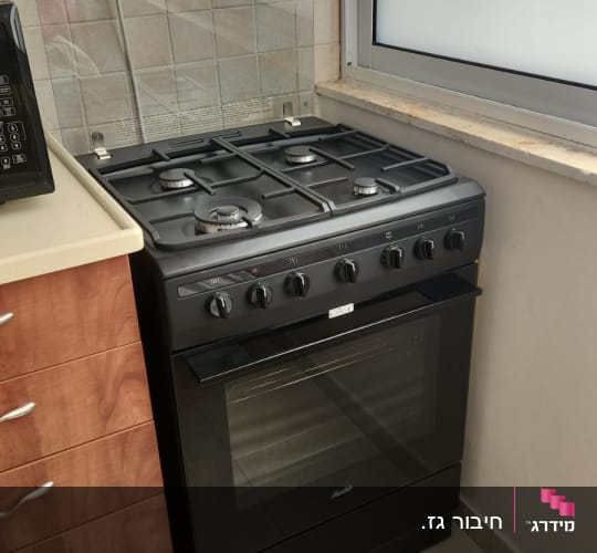 תנור משולב כיריים גז שחור מותקן במטבח